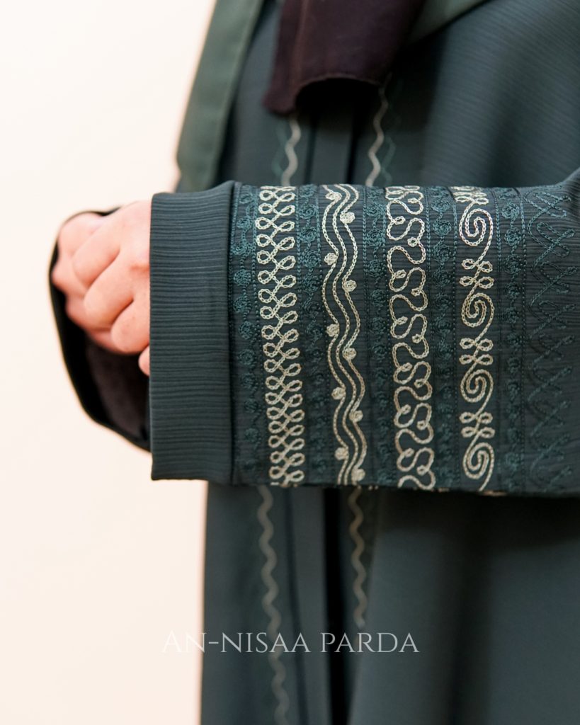 Close-up of arabesque satin stitch embroidery on abaya sleeve